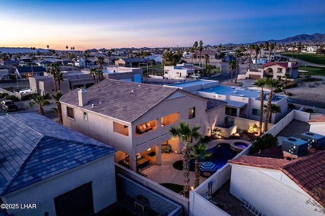 aerial view at dusk featuring a residential view and a mountain view