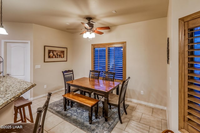 dining room with light tile patterned floors, baseboards, and a ceiling fan