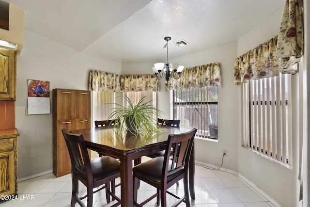 tiled dining space with an inviting chandelier