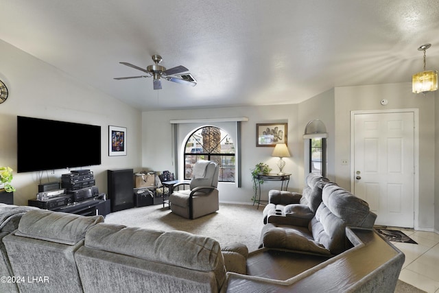 tiled living room with a textured ceiling, vaulted ceiling, and ceiling fan