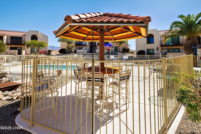 view of patio / terrace featuring a community pool and fence