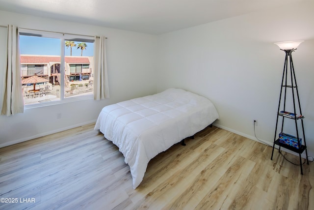 bedroom featuring baseboards and wood finished floors