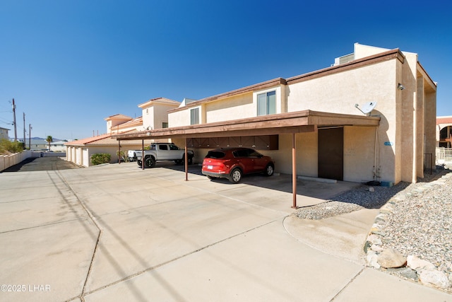 exterior space featuring stucco siding and covered parking