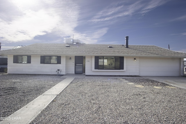 ranch-style house with an attached garage, driveway, and a shingled roof