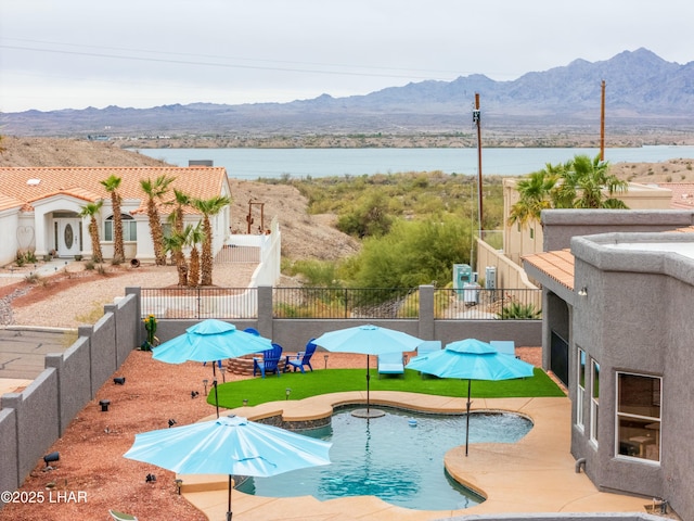 view of swimming pool featuring a mountain view, a patio, a fenced in pool, and fence