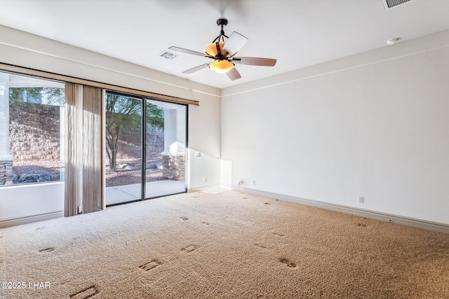 unfurnished room featuring ceiling fan, carpet floors, visible vents, and baseboards