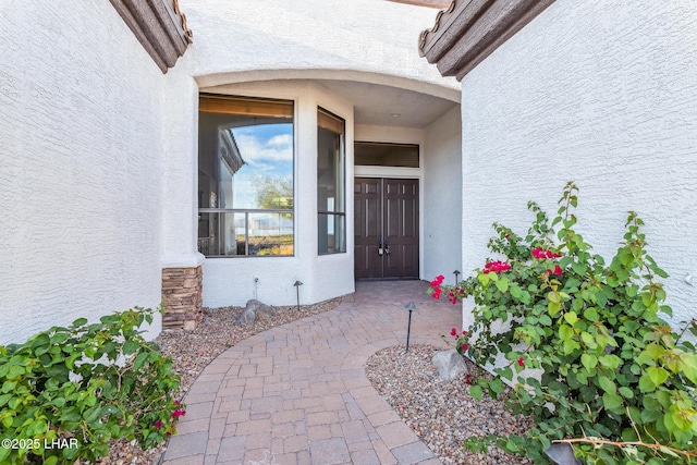 view of exterior entry featuring stucco siding