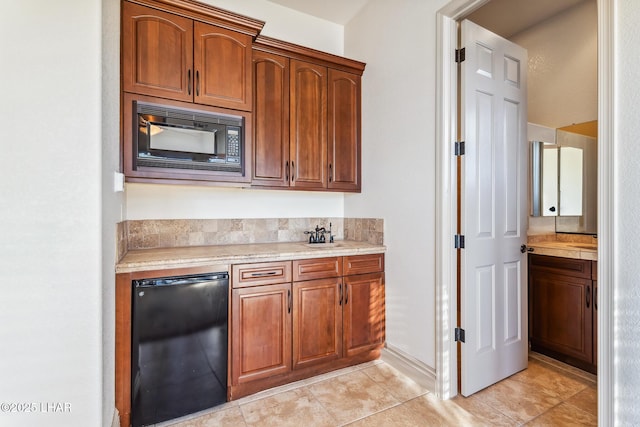 kitchen with light tile patterned flooring, fridge, brown cabinetry, black microwave, and light countertops