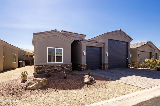 view of front of property featuring an attached garage, stone siding, decorative driveway, and stucco siding