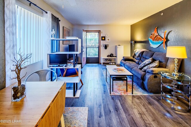 living room featuring wood-type flooring and a textured ceiling