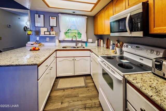 kitchen with hardwood / wood-style floors, sink, white cabinets, white electric range oven, and light stone counters