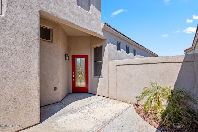 view of exterior entry with a patio area