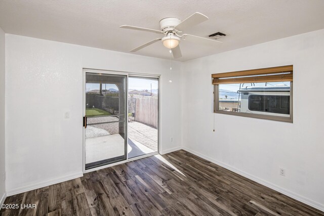 spare room featuring dark wood-type flooring and ceiling fan