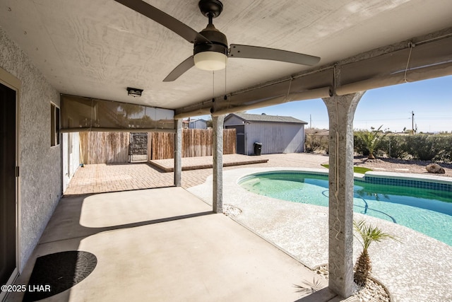 view of swimming pool with ceiling fan and a patio area