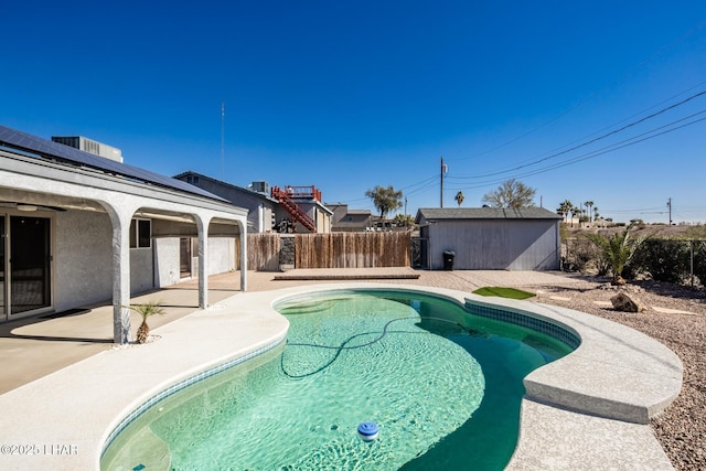 view of swimming pool with a patio and a storage shed