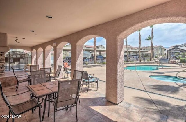 view of patio with a residential view, outdoor dining area, a community pool, and a community hot tub