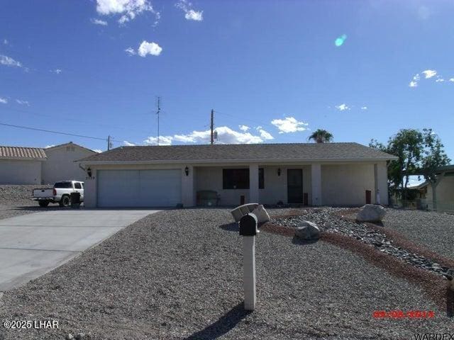 ranch-style home featuring an attached garage, driveway, and stucco siding