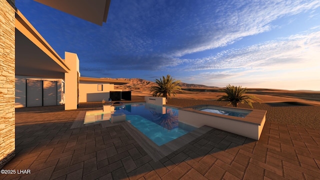 pool at dusk with a patio area and an in ground hot tub