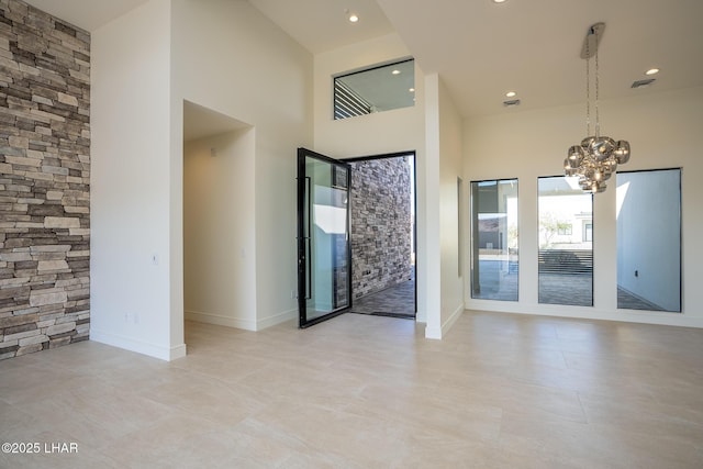 entryway with an inviting chandelier and a towering ceiling