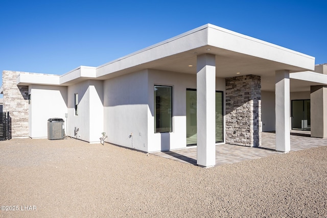 back of property with cooling unit and a patio area