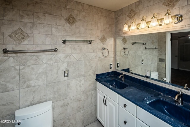 bathroom with vanity, tile walls, and toilet