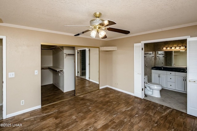 unfurnished bedroom with ornamental molding, dark wood-type flooring, and a textured ceiling