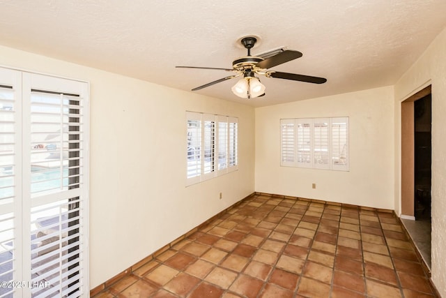 unfurnished room featuring ceiling fan and a textured ceiling