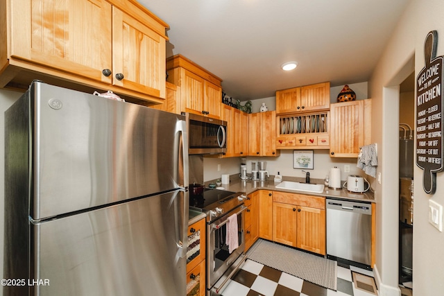 kitchen featuring appliances with stainless steel finishes, light brown cabinetry, a sink, tile patterned floors, and recessed lighting