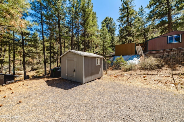 view of shed featuring fence