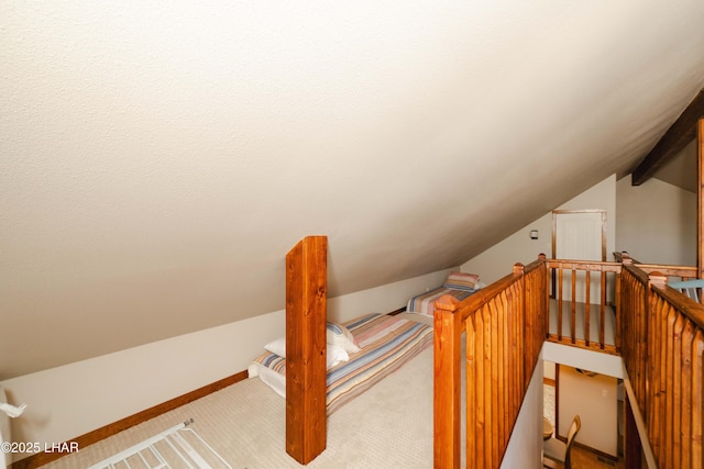 stairway with vaulted ceiling and carpet flooring