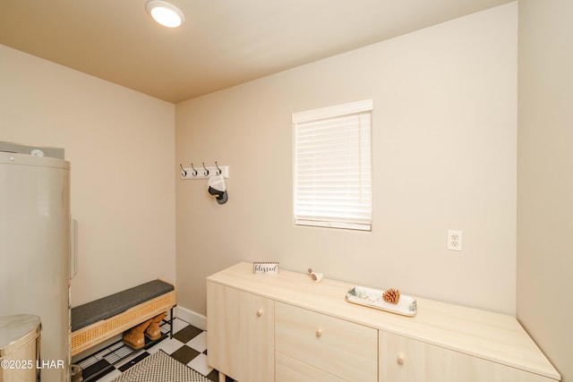 bathroom featuring water heater, baseboards, and tile patterned floors