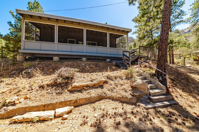 back of house with a sunroom and stairs