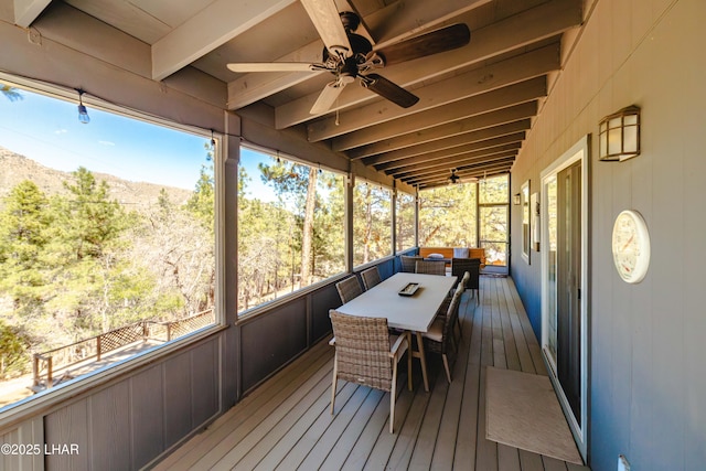 wooden deck with a mountain view, a ceiling fan, and outdoor dining space