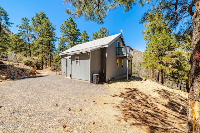 view of home's exterior featuring roof with shingles and a deck