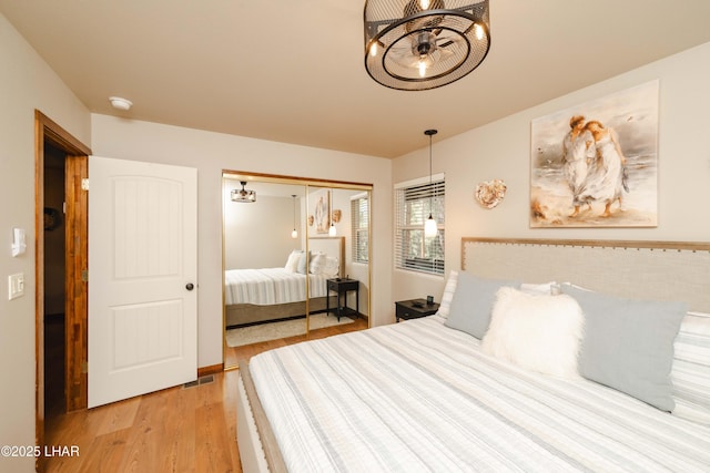 bedroom with light wood-style floors, a closet, and visible vents