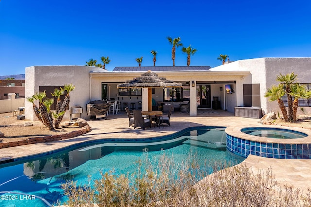 view of swimming pool with an in ground hot tub and a patio