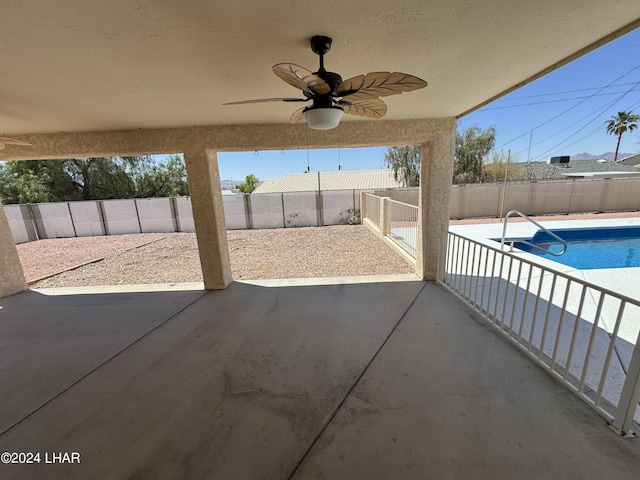 view of patio / terrace with ceiling fan and a fenced in pool