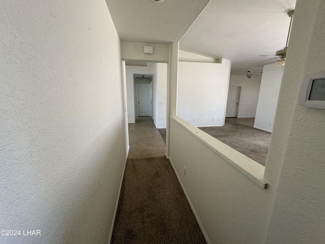 corridor featuring carpet floors and a textured ceiling