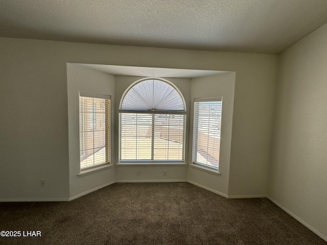 carpeted empty room with a textured ceiling