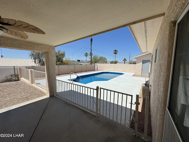 view of swimming pool featuring ceiling fan and a patio area