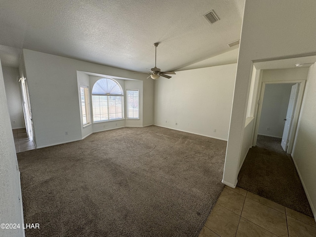 carpeted spare room featuring ceiling fan, lofted ceiling, and a textured ceiling