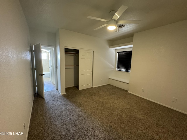 unfurnished bedroom featuring ceiling fan, dark carpet, and a closet