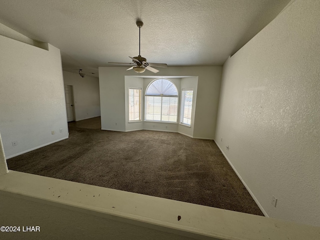 carpeted empty room featuring ceiling fan and a textured ceiling