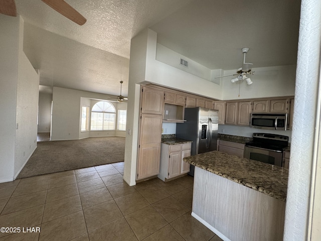 kitchen with light brown cabinetry, carpet flooring, ceiling fan, and appliances with stainless steel finishes