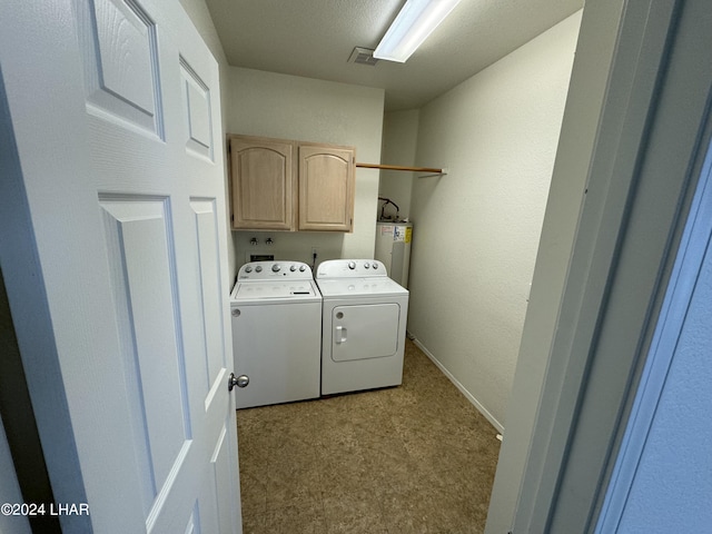 clothes washing area featuring cabinets, separate washer and dryer, and water heater