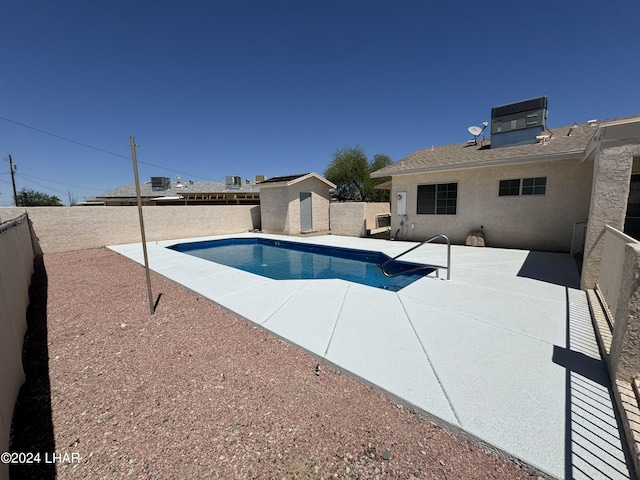 view of pool featuring a shed, a patio area, and central air condition unit