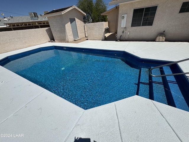 view of swimming pool featuring a storage unit