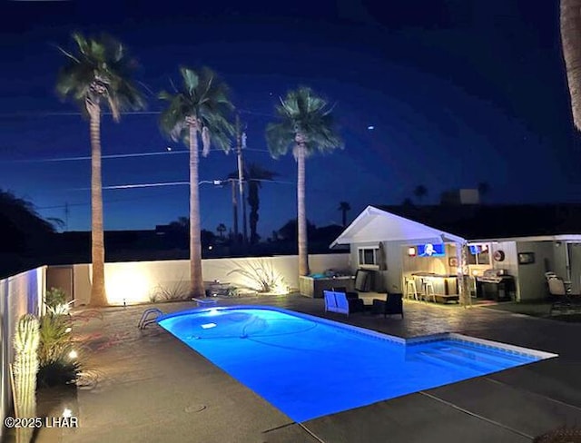 2593 Tradewind Dr, Lake Havasu City, AZ 86403 - pool at night featuring a patio area and a fenced backyard