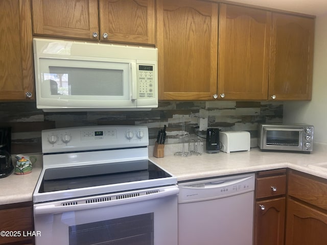 2085 Mesquite Ave Unit 76, Lake Havasu City, AZ 86403 - kitchen with white appliances, light countertops, backsplash, and brown cabinetry