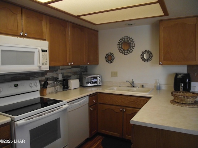 2085 Mesquite Ave Unit 76, Lake Havasu City, AZ 86403 - kitchen with white appliances, a sink, light countertops, brown cabinets, and backsplash